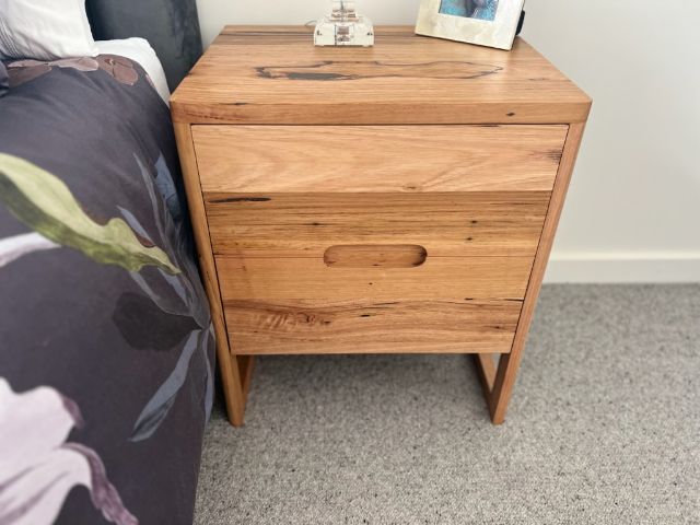 Two-drawer bedside table in natural hardwood, perfect for modern bedrooms.