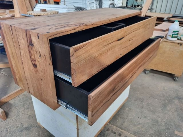 Custom floating bathroom vanity made from reclaimed Australian Messmate timber with two soft-close drawers and a matte black interior.