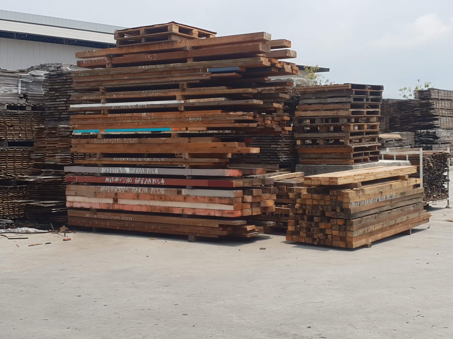 Stacks of reclaimed hardwood timber beams at Reconstructed’s Geelong warehouse, carefully sourced and prepared for sustainable reuse