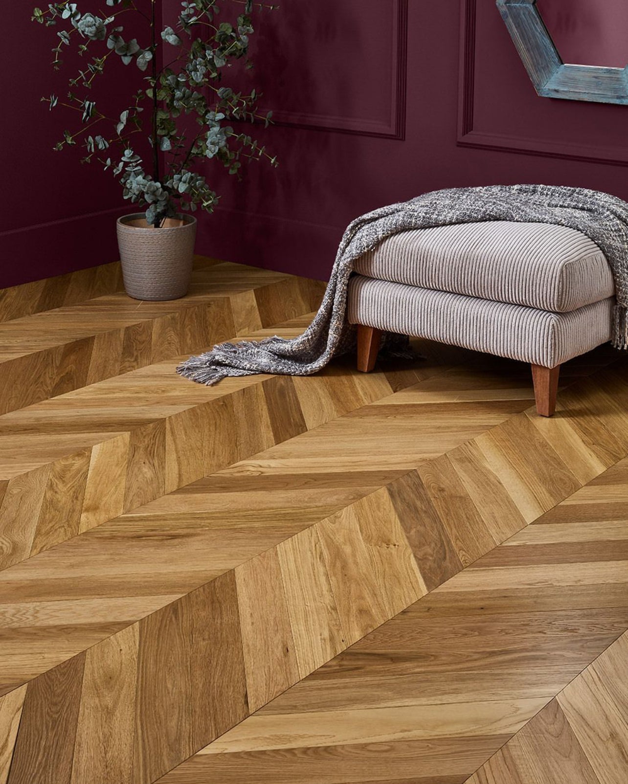 Chevron pattern recycled engineered hardwood flooring adding texture to a modern lounge corner