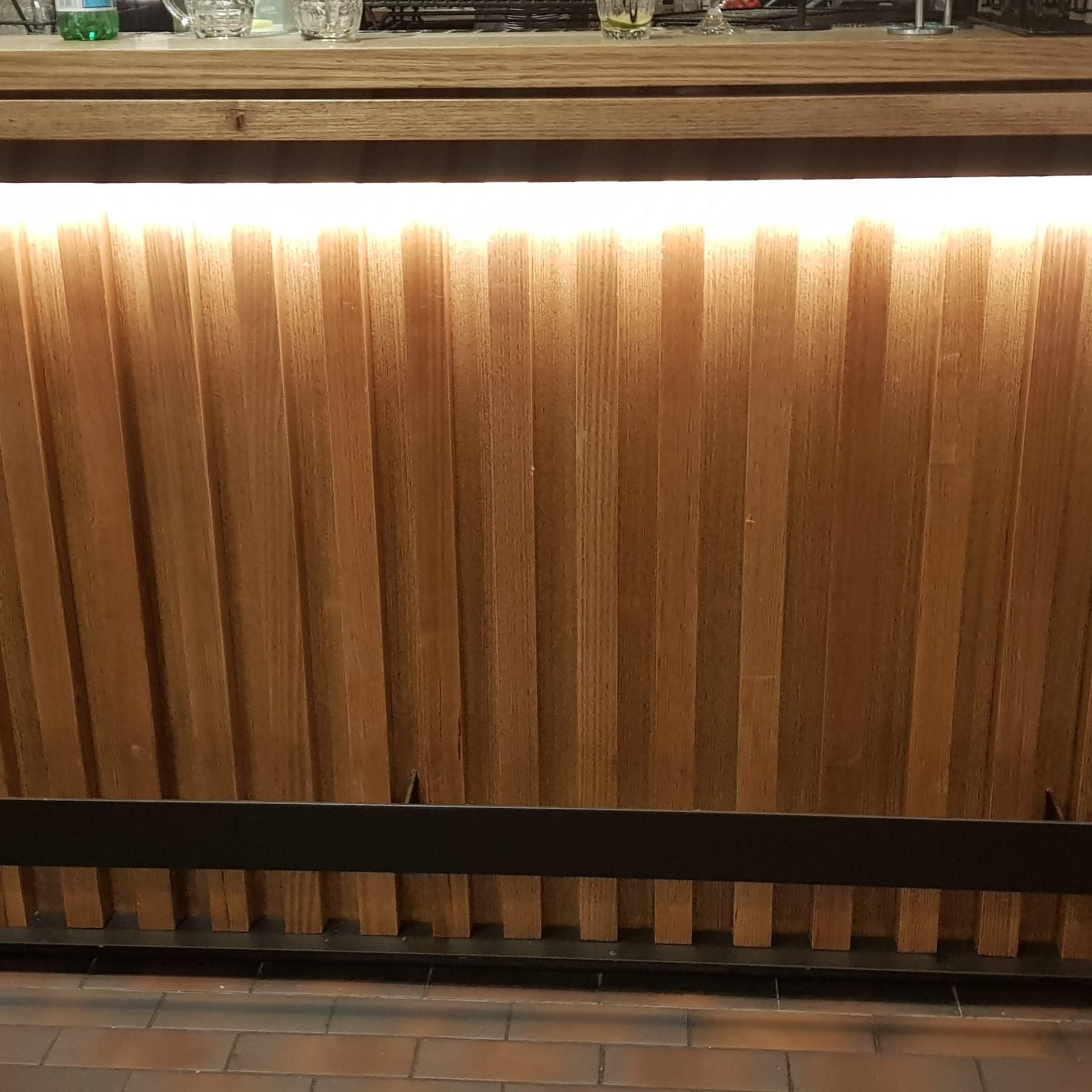 Recycled timber panelling installed on bar front with LED strip lighting
