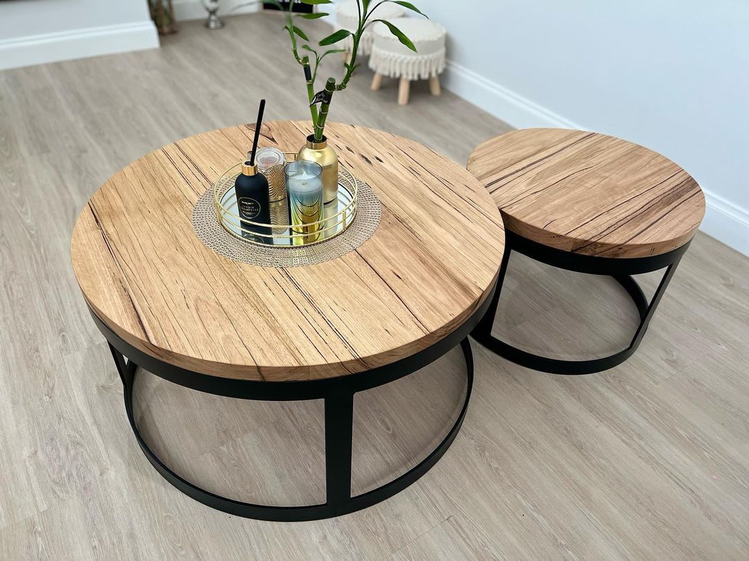 Pair of round nesting coffee tables with timber tops and black metal frames, natural grain finish.