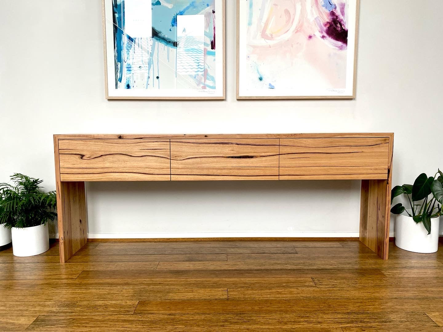 Solid timber console table with three drawers and clean grain pattern, ideal for hallway or dining space.