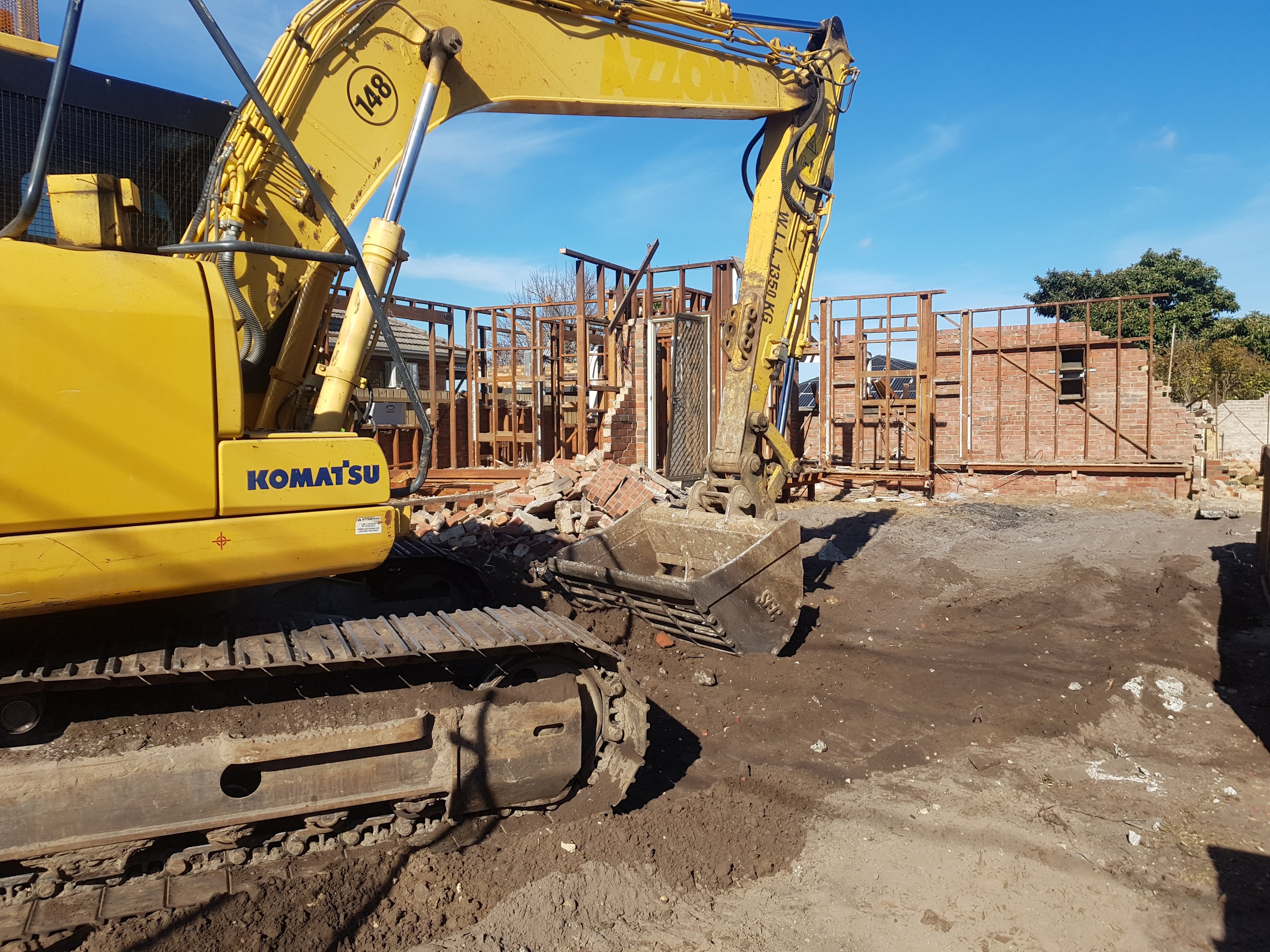 Step 1 of the timber recycling process — recovered structural hardwood being sourced from a demolition site for reuse.
