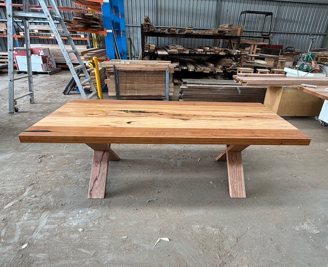 Front view of Bellanie recycled messmate dining table in recycled timber with wide plank top and solid timber legs
