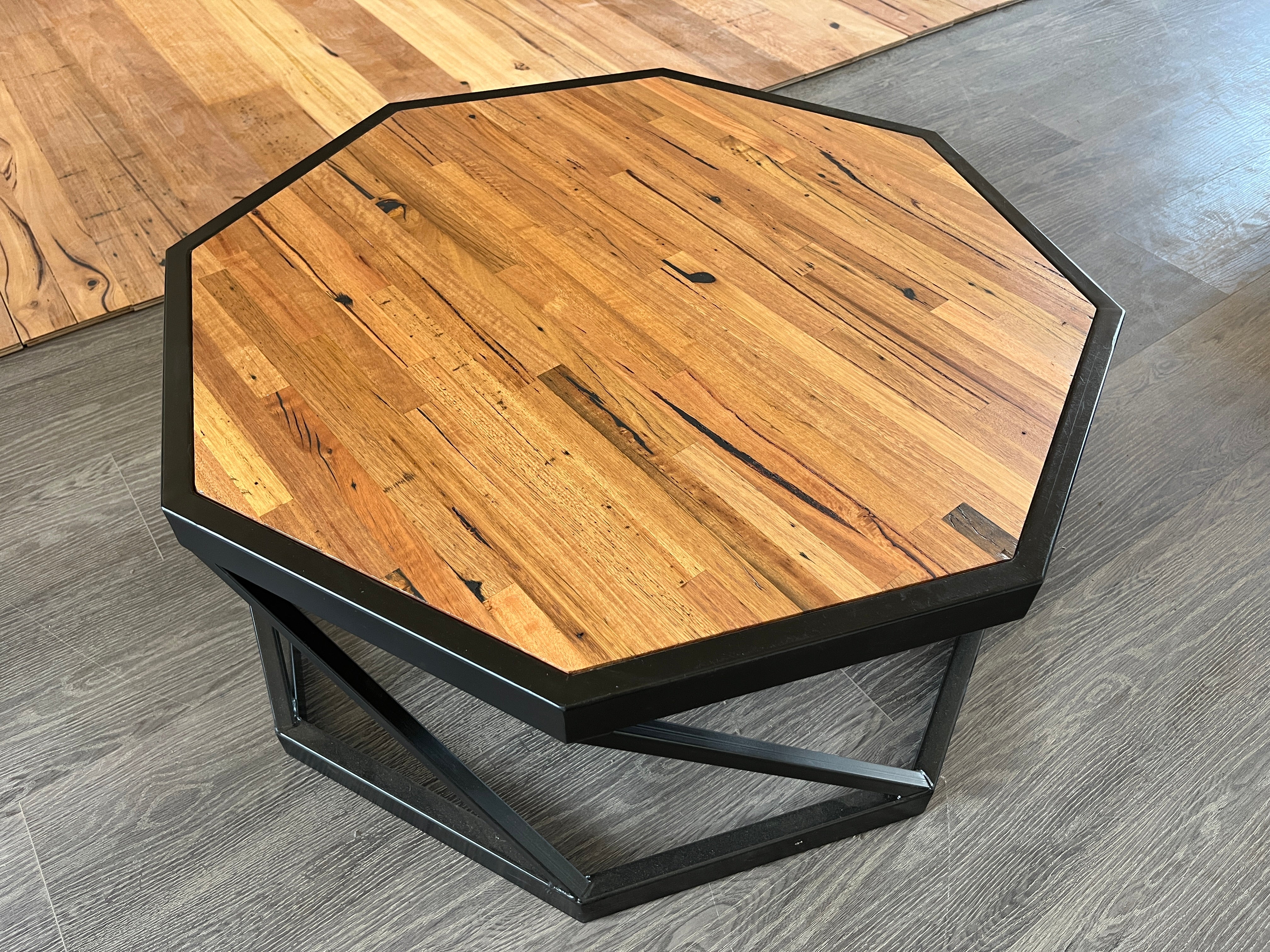 Octagonal coffee table with reclaimed timber top and black steel frame, modern geometric design.